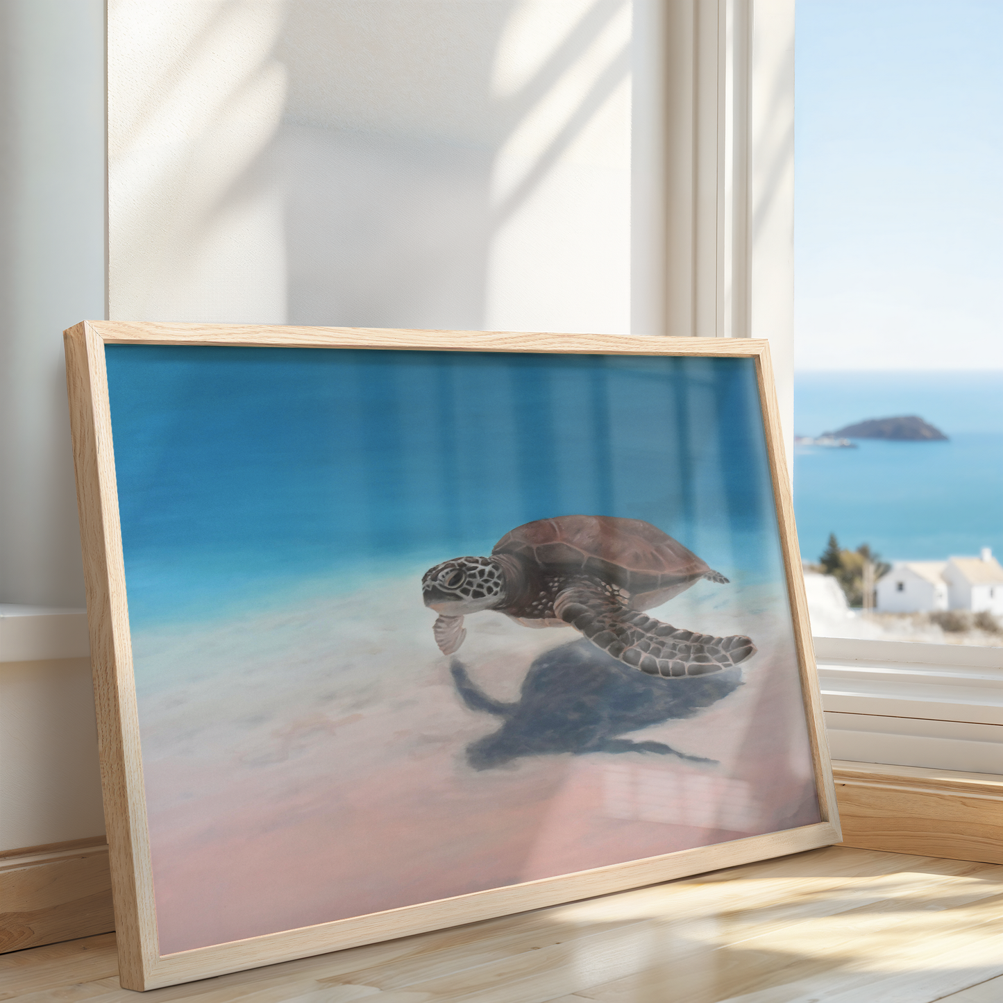Large sea turtle painting on canvas in soft blue and blush tones, framed in natural wood, leaning against a window with ocean view